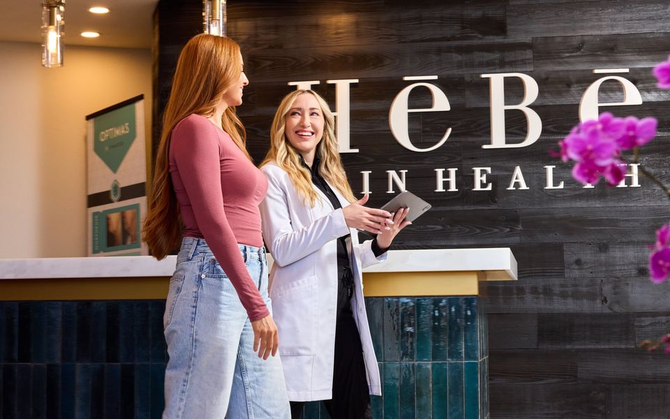 Nicole Smith, MSPA, reviewing a treatment plan on a tablet with a patient at HēBē Skin Health